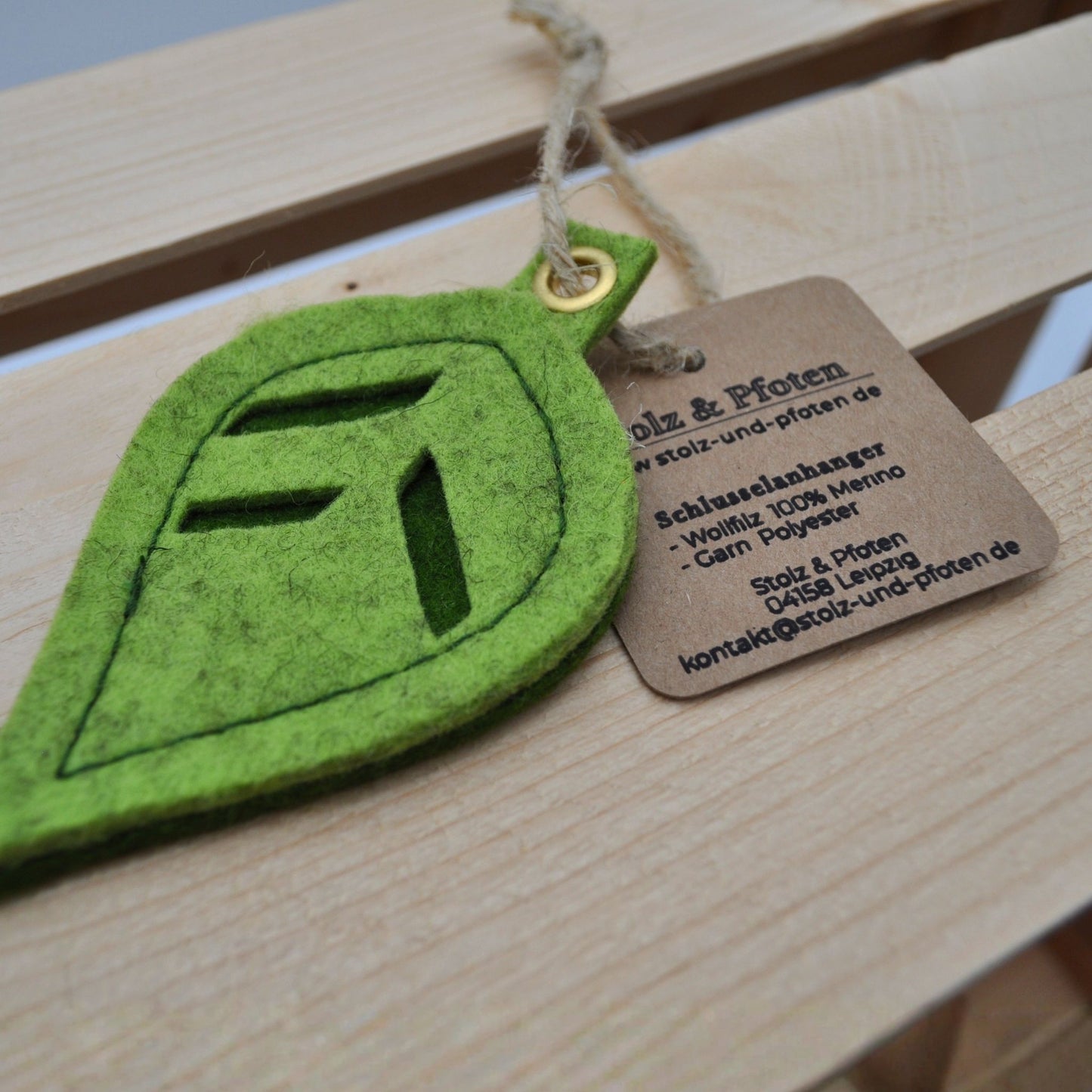 Nahaufnahme des Schlüsselanhängers aus Merino-Wollfilz mit Produktinformationen auf einem an Hanfschnur befestigten Etikett