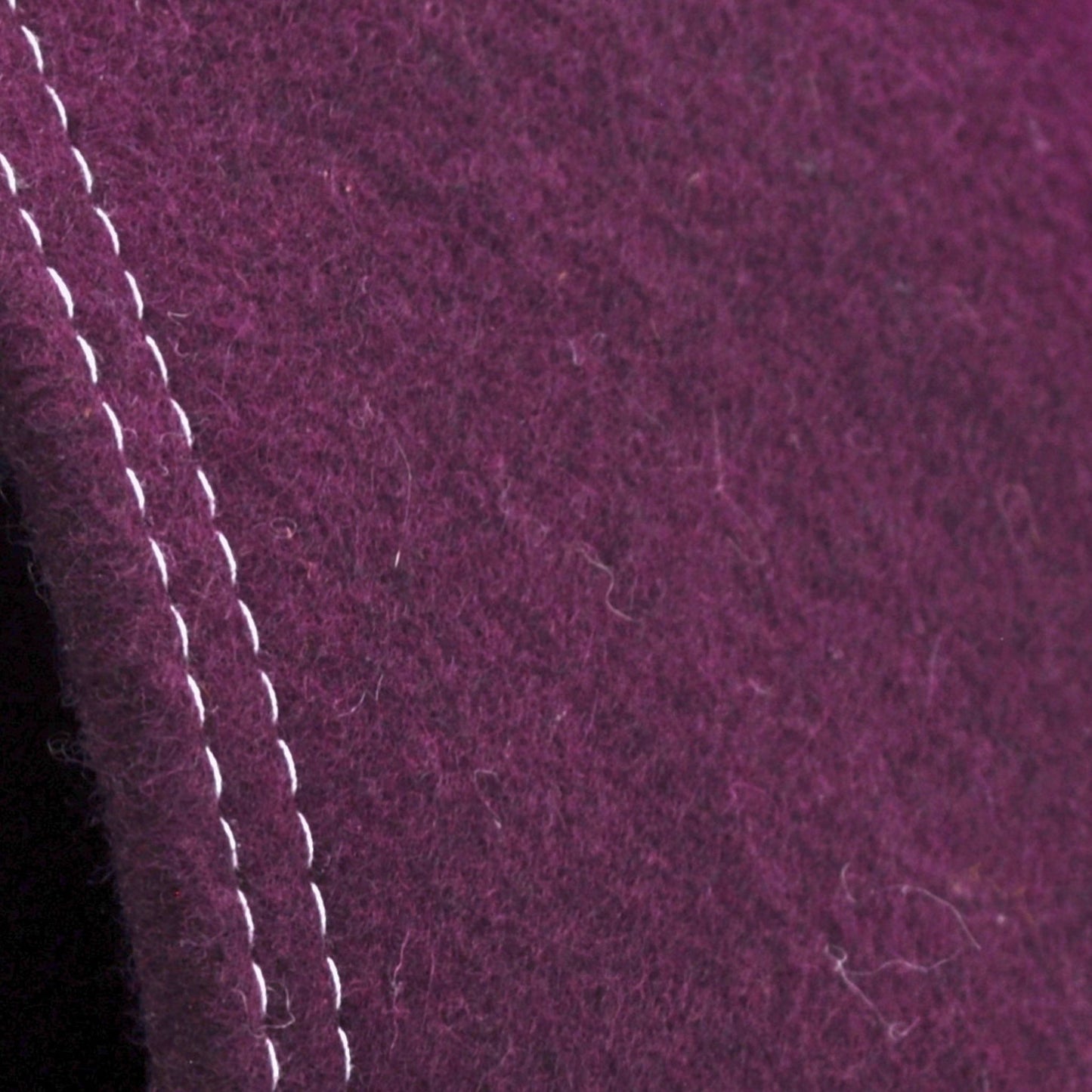 Detailaufnahme der Aubergine-farbenen Katzenhöhle aus Filz, zeigt Materialstruktur und Kontrast zwischen hellgrauer Naht und aubergine-farbenen Wollfillz