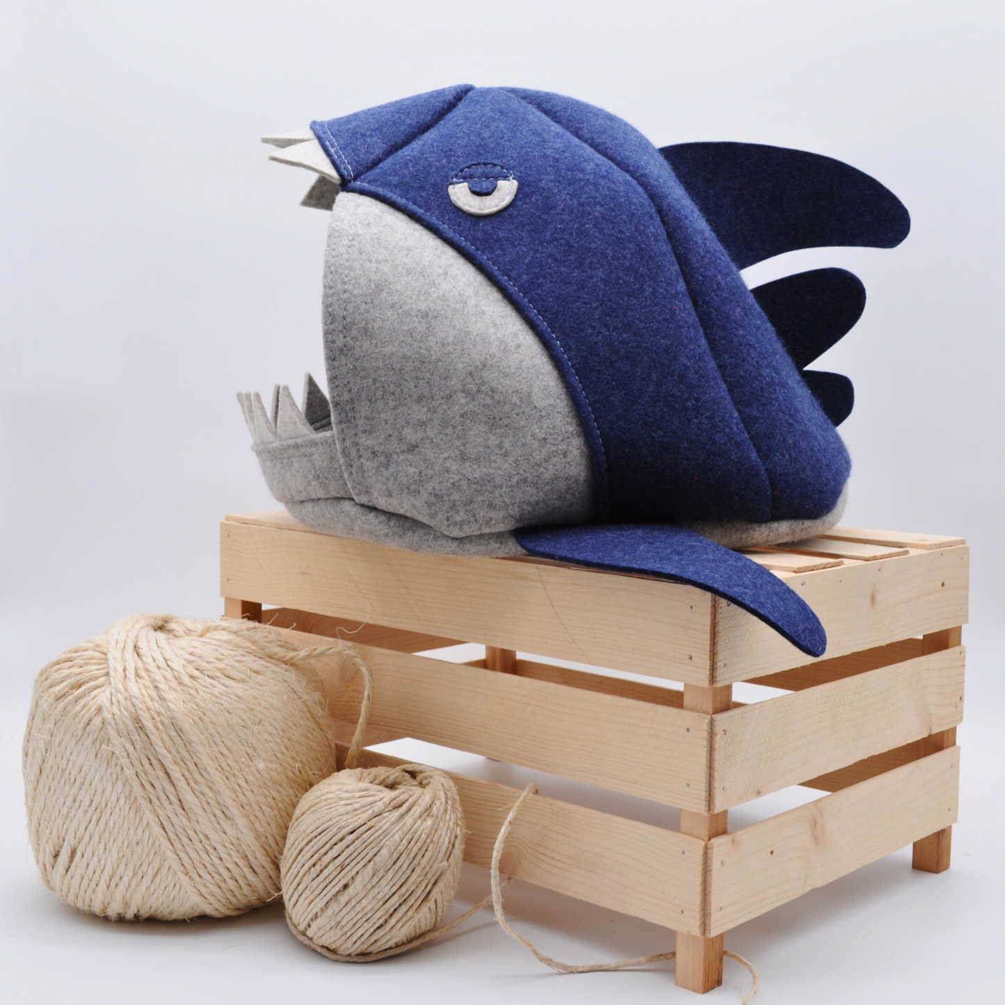 Grau-blaue Katzenhöhle im Makohai-Stil, auf Holzkiste präsentiert mit platziert mit Sisalball im Vordergrund – natürliche Wohnatmosphäre