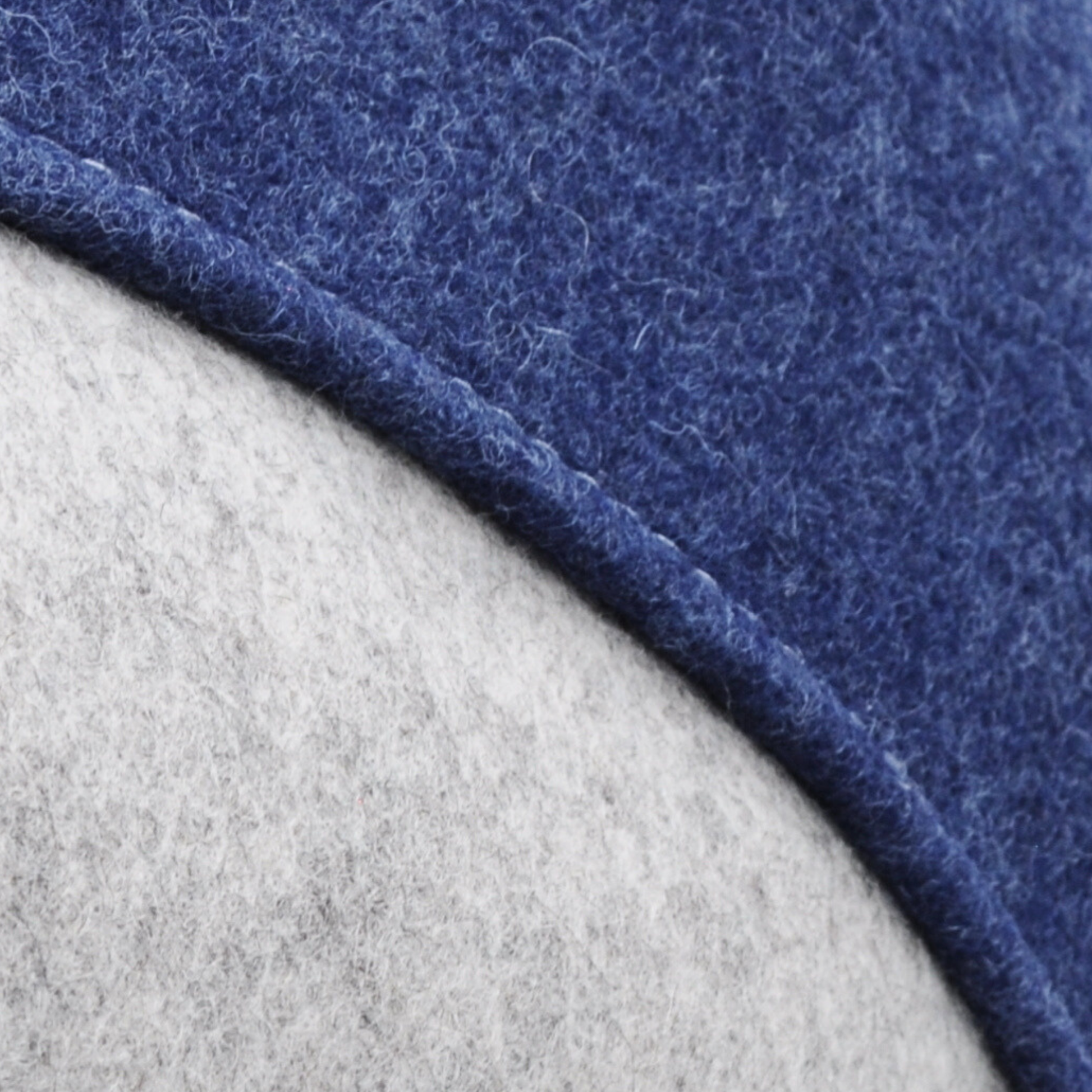 Detailaufnahme der grau-blauen Katzenhöhle aus Merino-Wollfilz, zeigt Naht und Filzstruktur