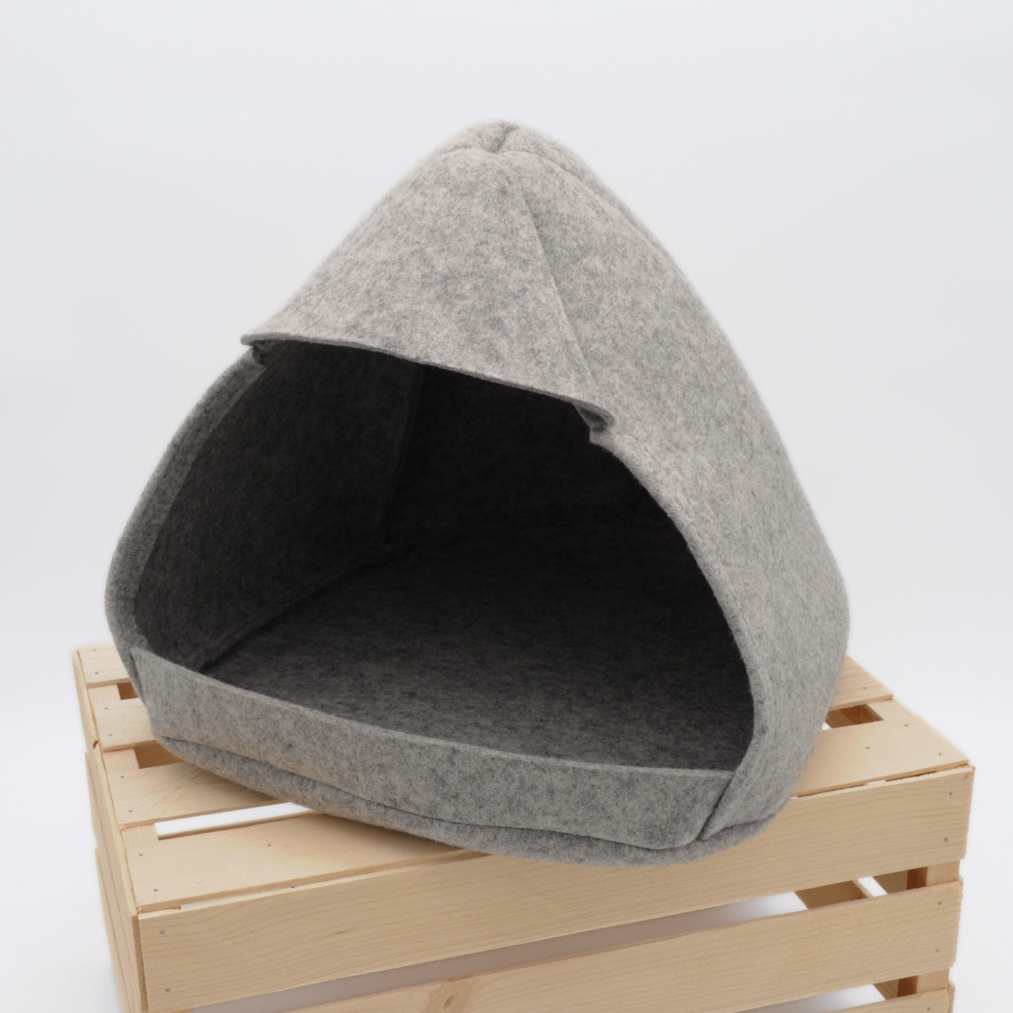Graue Filz-Katzenhöhle in klarer, moderner Form, 45-Grad-Ansicht auf Holzkiste