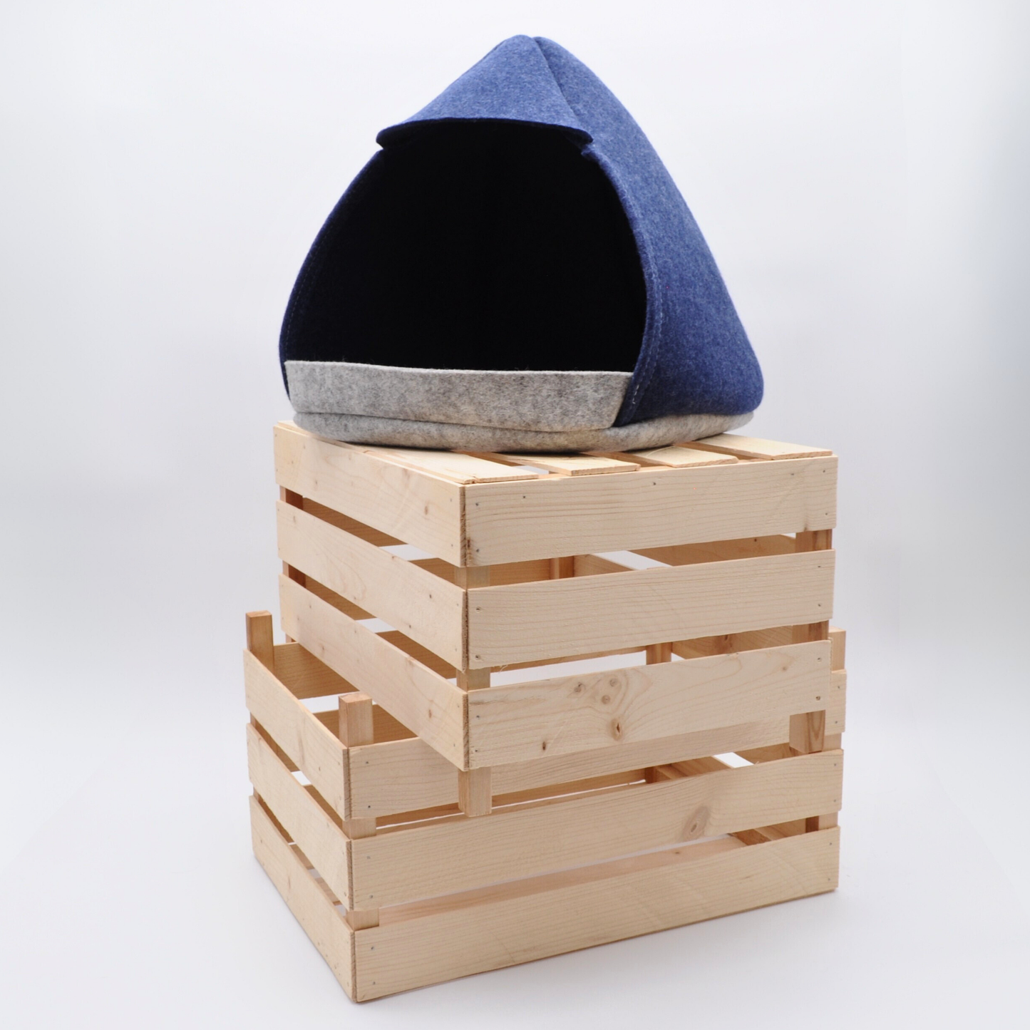 Zweifarbige Katzenhöhle aus Wollfilz, graue und blaue Elemente auf Holzkisten inszeniert erschafft stilvolle Wohnatmosphäre