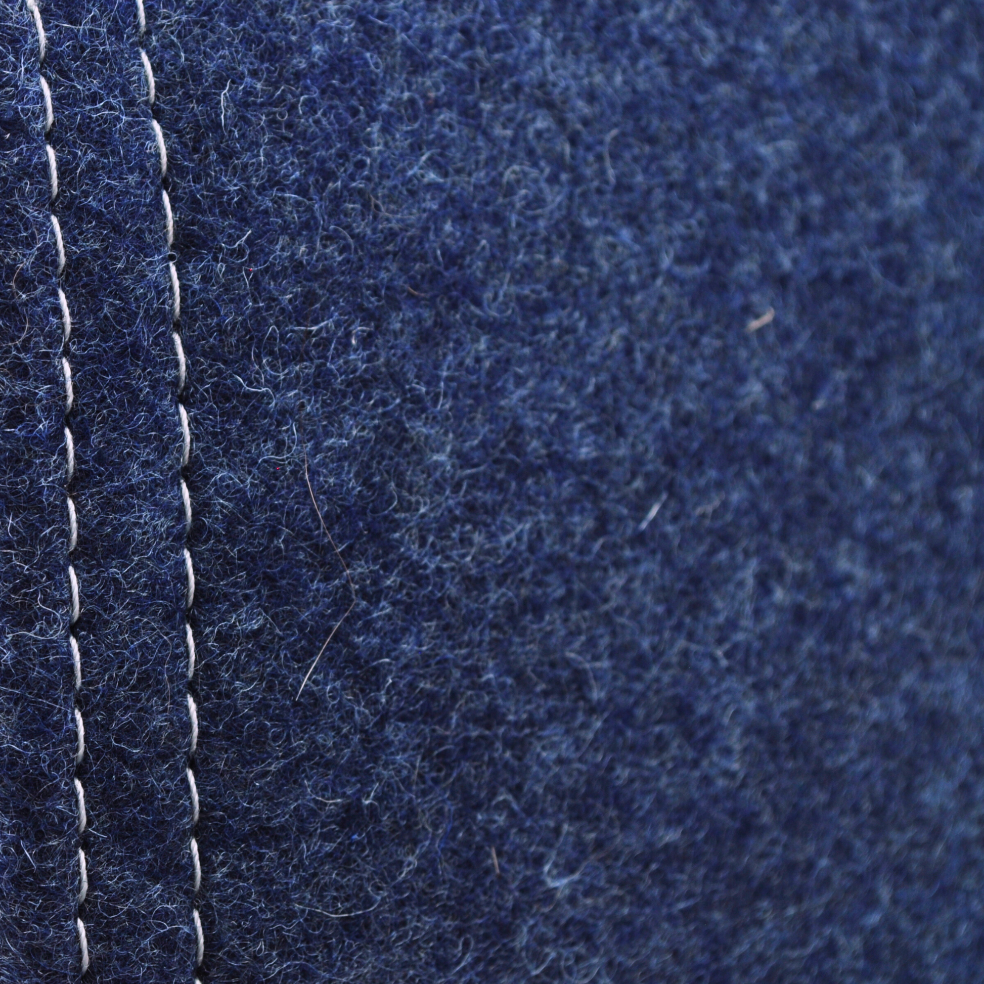 Detailaufnahme der indigo-blauen Katzenhöhle aus Filz, zeigt Materialstruktur und Kontrast zwischen hellgrauer naht und indigo-blauem Wollfillz