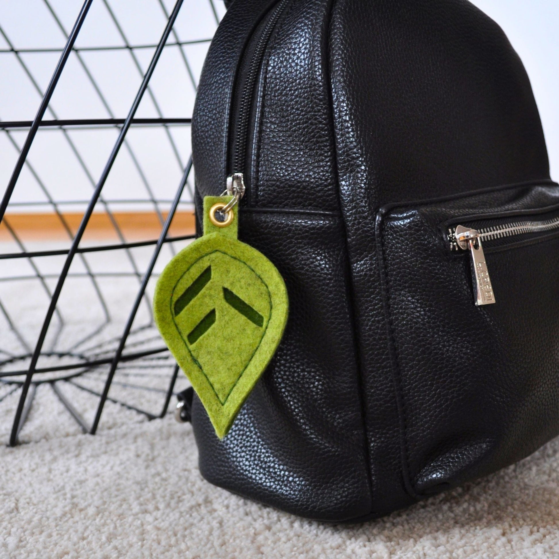 Schlüsselanhänger in Blattform aus Merino-Wollfilz als Taschenanhänger an einem schwarzen Lederrucksack