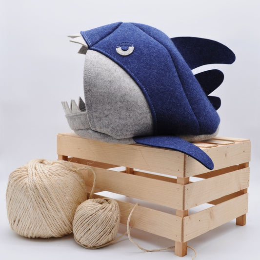 Grau-blaue Katzenhöhle im Makohai-Stil, auf Holzkiste präsentiert mit platziert mit Sisalball im Vordergrund – natürliche Wohnatmosphäre