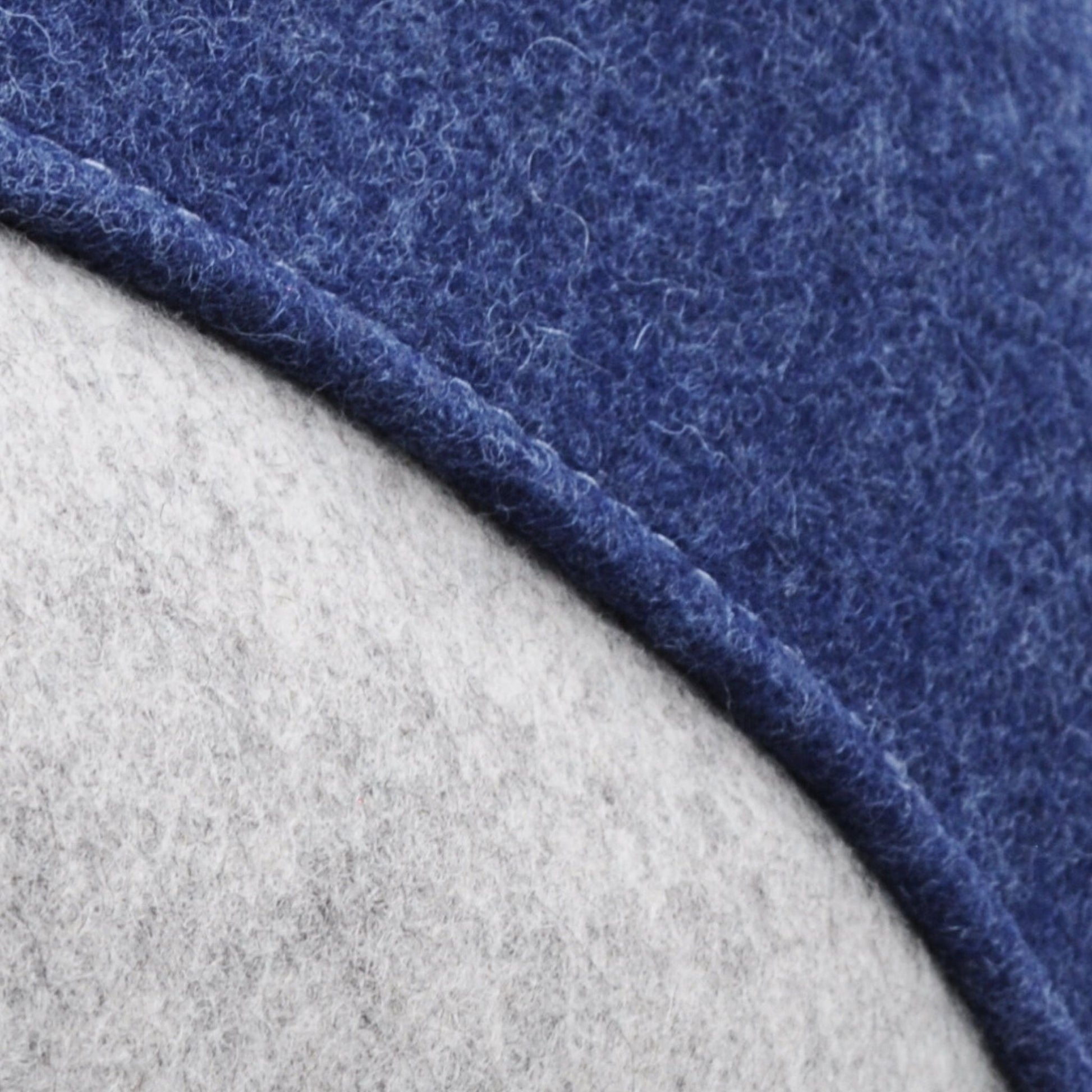 Detailaufnahme der grau-blauen Katzenhöhle aus Merino-Wollfilz, zeigt Naht und Filzstruktur