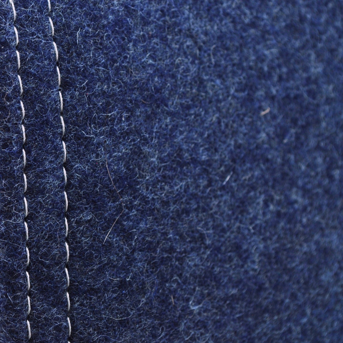 Detailaufnahme der indigo-blauen Katzenhöhle aus Filz, zeigt Materialstruktur und Kontrast zwischen hellgrauer naht und indigo-blauem Wollfillz