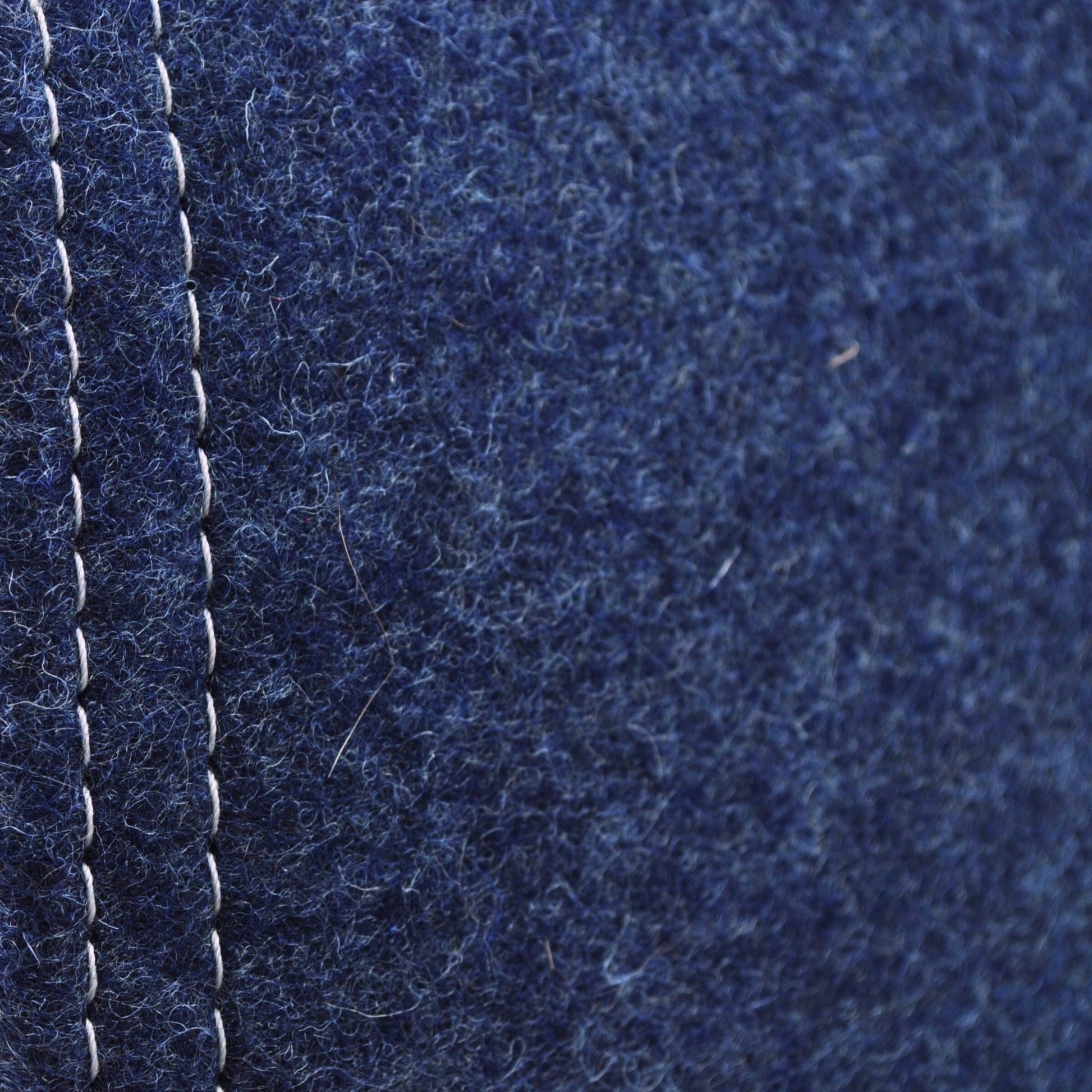 Detailaufnahme der indigo-blauen Katzenhöhle aus Filz, zeigt Materialstruktur und Kontrast zwischen hellgrauer naht und indigo-blauem Wollfillz