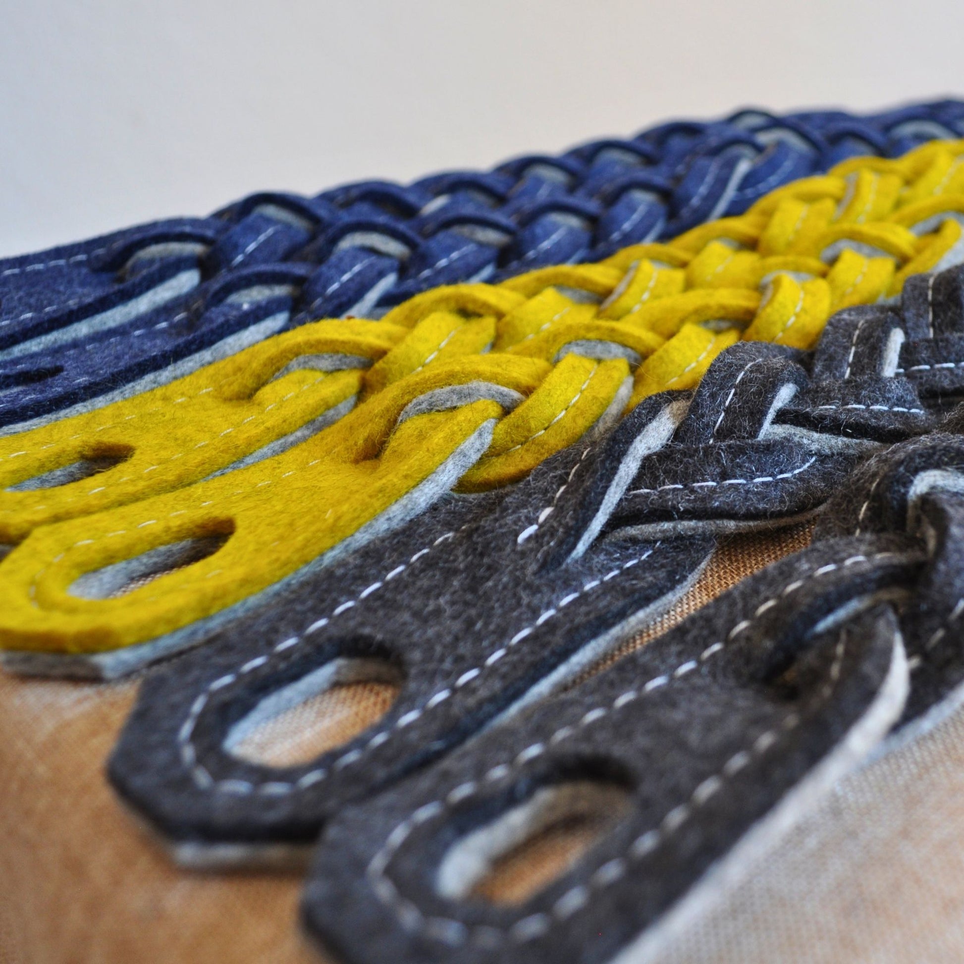 Türwächter aus Merino-Wollfilz in Anthrazit, Senf und Indigo, zeigt Material, Form und Nahtdetails